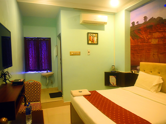 Standard AC Room with modern amenities and comfortable bedding at a hotel near Chatram bus stand Trichy.